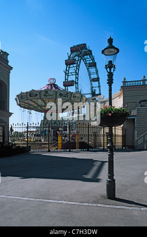 Austria, Vienna, Prater park amusement park rides with lamp post in foreground Stock Photo