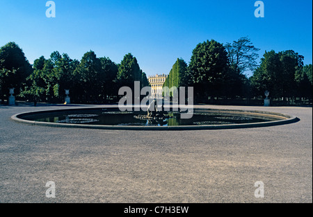 Austria, Vienna, water fountain with Schonbrunn Palace seen far in the background between trees Stock Photo