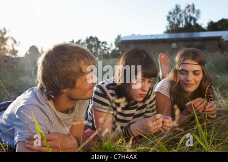 Three friends lying down amongst the timothy grass Stock Photo
