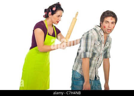 Angry wife beaut with a pin rolling her drunk unfaithful husband isolated on white background Stock Photo