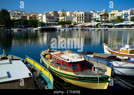 Colourful traditional fishing boats line Lake Voulismeni in Agios Nikolaos on the Greek island of Crete Stock Photo