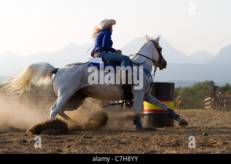 Cowgirl on horseback riding in the ladies barrel racing event, Stock Photo