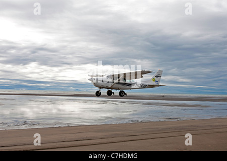 Single engine prop plane takes off from a sandy beach, Lake Clark National Park, Alaska, United States of America Stock Photo