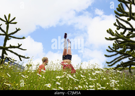 Woman doing handstand in garden Stock Photo