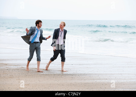 Businessmen walking on beach Stock Photo