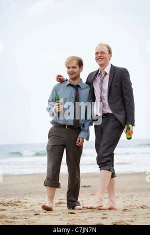 Businessmen walking on beach Stock Photo