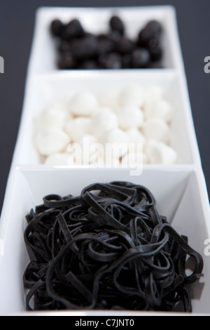 Black and white candies in dish Stock Photo