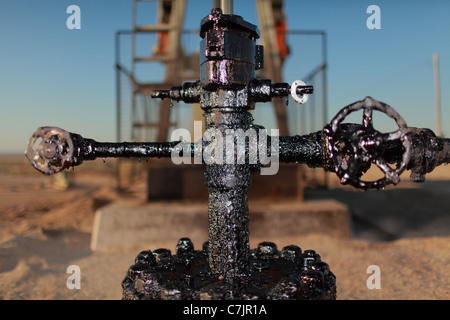 Close up of grimy pipes at oil field Stock Photo