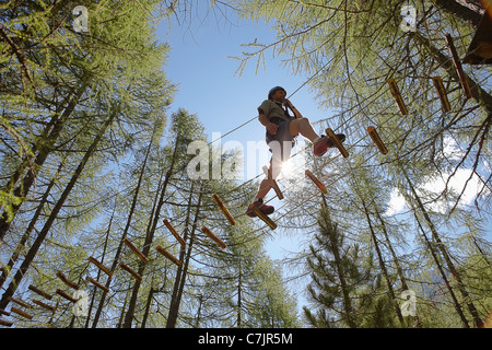 Person doing treetop obstacle course Stock Photo