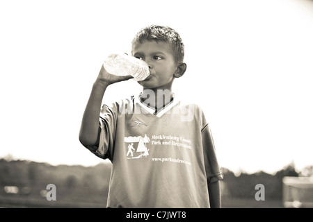 portrait of boy drinking bottled water
