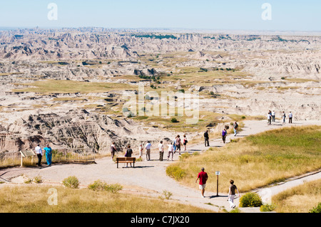 Tourists view the scenery in Badlands National Park from a scenic overlook. Stock Photo