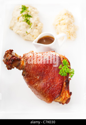original German BBQ pork knuckle served with mashed potatoes and sauerkraut isolated on white ,MORE DELICIOUS FOOD ON PORTFOLIO Stock Photo