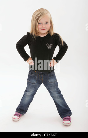 Five year old girl standing with hands on hips. Stock Photo