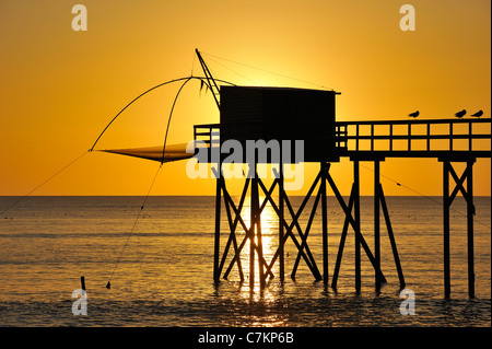 Traditional carrelet fishing hut with lift net on the beach at sea at sunset, Loire-Atlantique, Pays de la Loire, France Stock Photo