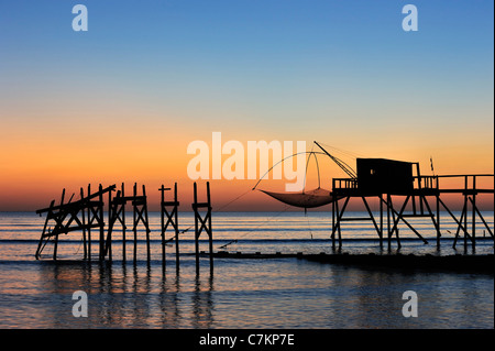 Traditional carrelet fishing hut with lift net on the beach at sea at sunset, Loire-Atlantique, Pays de la Loire, France Stock Photo