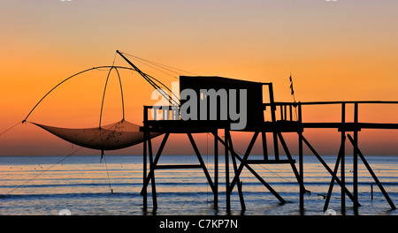 Traditional carrelet fishing hut with lift net on the beach at sea at sunset, Loire-Atlantique, Pays de la Loire, France Stock Photo