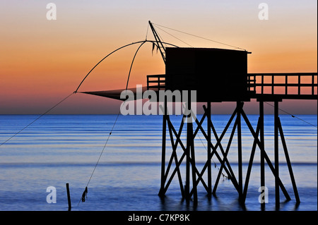 Traditional carrelet fishing hut with lift net on the beach at sea at sunset, Loire-Atlantique, Pays de la Loire, France Stock Photo