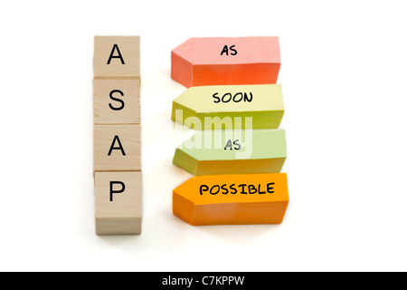 ASAP, As Soon As Possible spelled out on wooden blocks and colorful arrow shaped sticky notes. Stock Photo