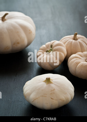 white pumpkins and squash sitting on a rustic black wooden board Stock Photo