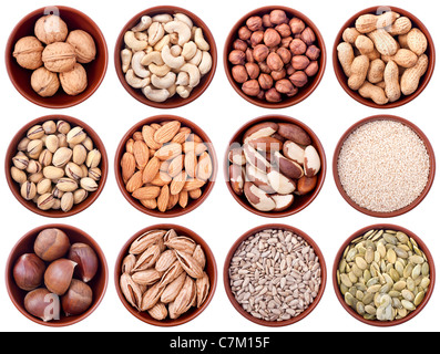 assortment of nuts and seeds in ceramic bowls isolated on white background Stock Photo