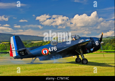 An historic Grumman TBM-3E 'Avenger' torpedo bomber starting up its engines (see puff of smoke) ready for take-off Stock Photo