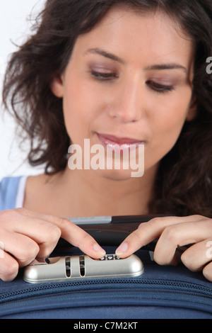Woman unlocking the combination on her suitcase Stock Photo