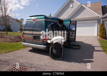 Man with spinal cord injury using magnetized remote to open his accessible vehicle Stock Photo