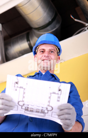 Plumber with the schematics of an air conditioning system Stock Photo
