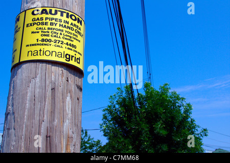 National grid caution sign on electrical power pole on new york city borough street, USA Stock Photo