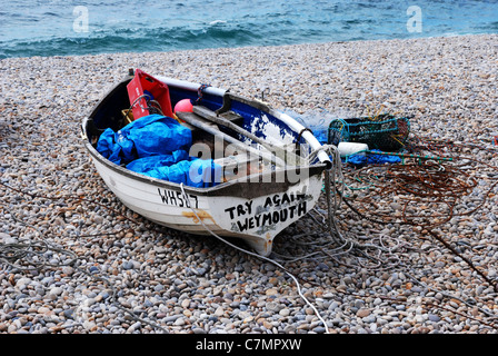 Small boat on beach at Chiswell Portland Dorset England  with [try again Weymouth] painted on its stern