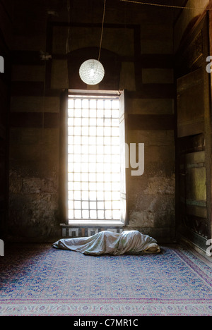 Man sleeping wrapped up in a linen at Qait Bey Mosque - City of the Dead - Cairo, Egypt Stock Photo