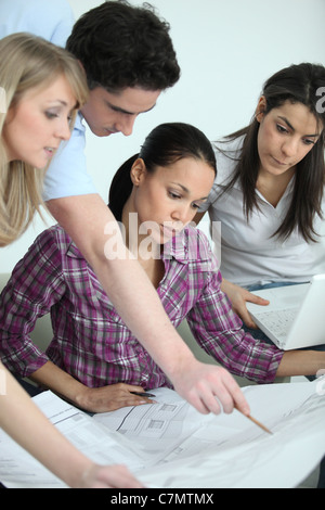 Team pointing at architect drawings Stock Photo