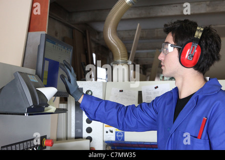 Young man operating factory machinery Stock Photo