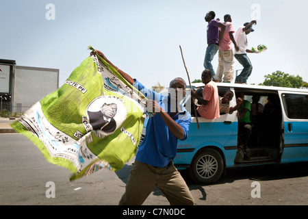 A jubilant supporter holds a flag campaign image of newly-elected President Michael Sata of the Opposition Patriotic Front Stock Photo