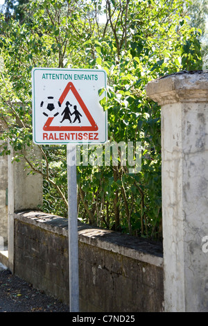 Road sign children playing with ball, Slow down motorists. Ralentissez Stock Photo