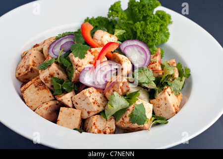 Fresh Thai food stir fry with tofu presented on a round white dish. Stock Photo