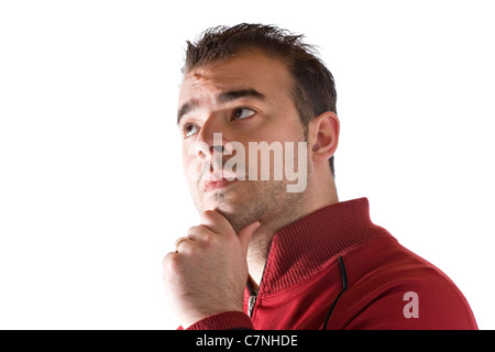 A young man thinking about something deeply with his hand on his chin. Stock Photo