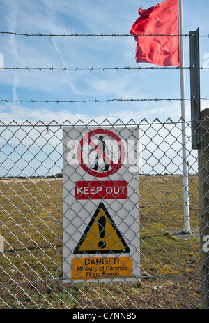 Red Live Firing Flag and Danger Sign On Perimeter Fence Of MOD British Army Firing Range Lydd Kent England Stock Photo