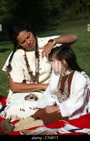 A Native American Indian woman braiding her childs hair Stock Photo