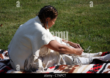 Native American Indian woman tying her moccasins Stock Photo