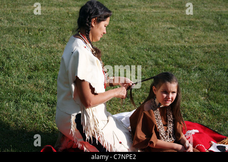 Native American Indian woman braiding the hair of a child Stock Photo