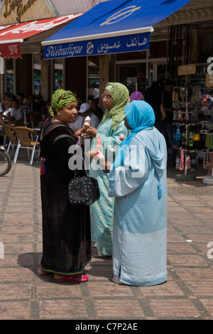 Three Moroccan ladies enjoying ice creams in Djemaa el Fna Square Stock Photo