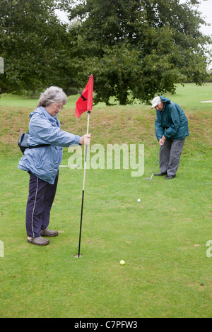 Elderly couple playing golf; Cornwall; UK Stock Photo