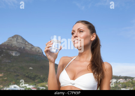 Woman in bikini drinking glass of water Stock Photo