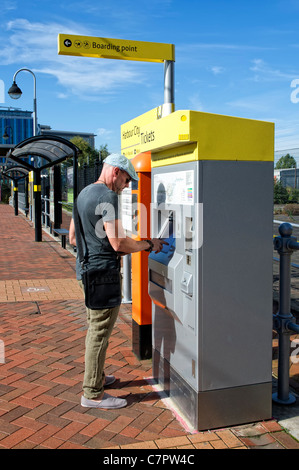 Young man buying ticket to use the Metrolink tram system in Salford ...