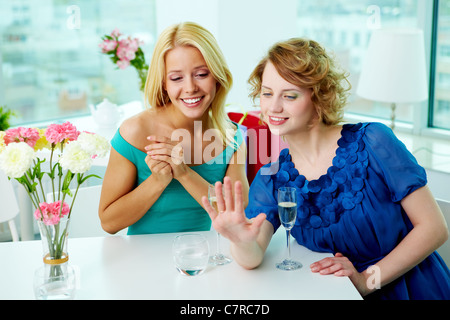 Young woman showing wedding ring to her girlfriend in cafe Stock Photo