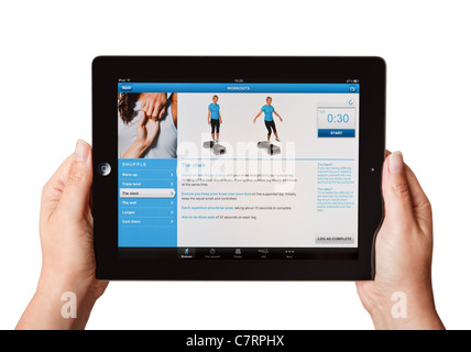 Female hands holding an iPad showing the BUPA fitness app Stock Photo