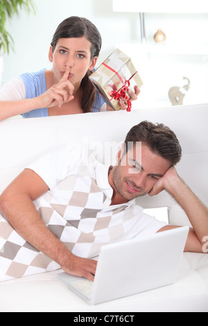 Woman surprising her boyfriend with a gift Stock Photo