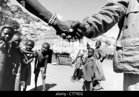 Sudan, Kordofan, hand shaking between soldier and locals Stock Photo