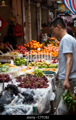 A man shopping for fresh fruit and vegetables in a local street market in Guangzhou, China.
